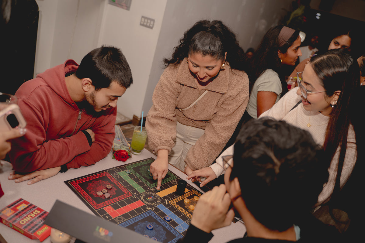 Friends playing Ludo Ghar at a community game night.